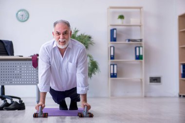 Mola sırasında fiziksel egzersiz yapan yaşlı bir erkek.