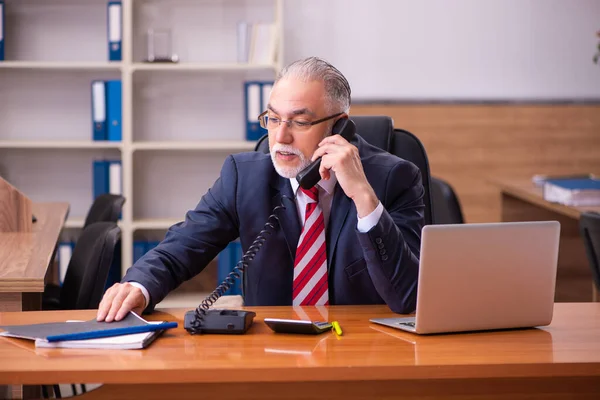 Παλιό αρσενικό υπάλληλο κάθεται στο γραφείο — Φωτογραφία Αρχείου