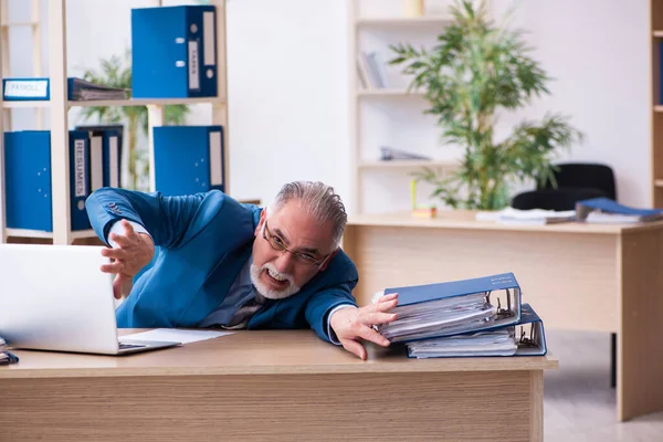 Vecchio contabile maschio infelice con il lavoro eccessivo sul posto di lavoro — Foto Stock