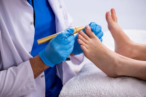 Podólogo tratando los pies durante el procedimiento — Foto de Stock