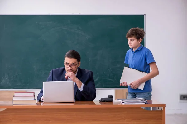 Jonge mannelijke leraar en schooljongen in de klas — Stockfoto