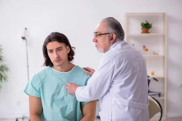 Jonge mannelijke patiënt op bezoek bij ervaren arts — Stockfoto