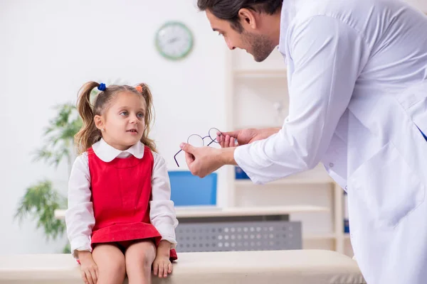 Menina pequena visitando jovem médico oculista masculino — Fotografia de Stock