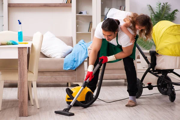 Νεαρός εργολήπτης καθαρίζει το σπίτι με τη μικρή του κόρη. — Φωτογραφία Αρχείου