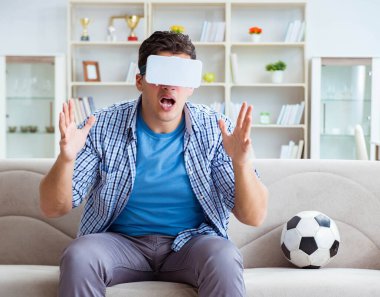Sanal gerçeklik gözlüğü takan bir adam futbol maçı izliyor.