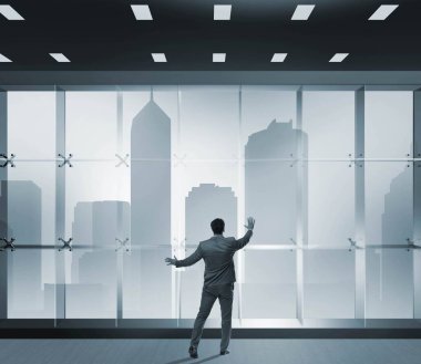 Ofis penceresinin önündeki işadamı yeni zorluklar düşünüyor