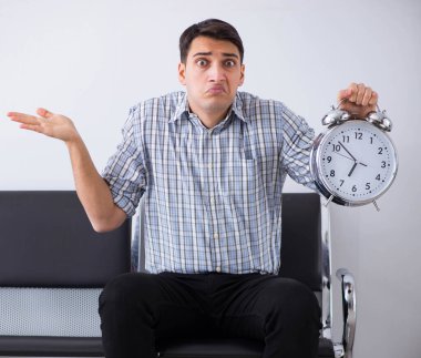 Adam sabırsızlıkla lobide bekliyor.