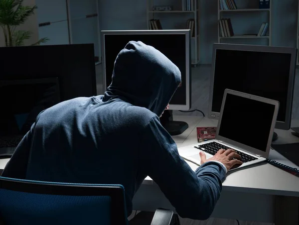 Хакер зламує комп'ютер вночі — стокове фото