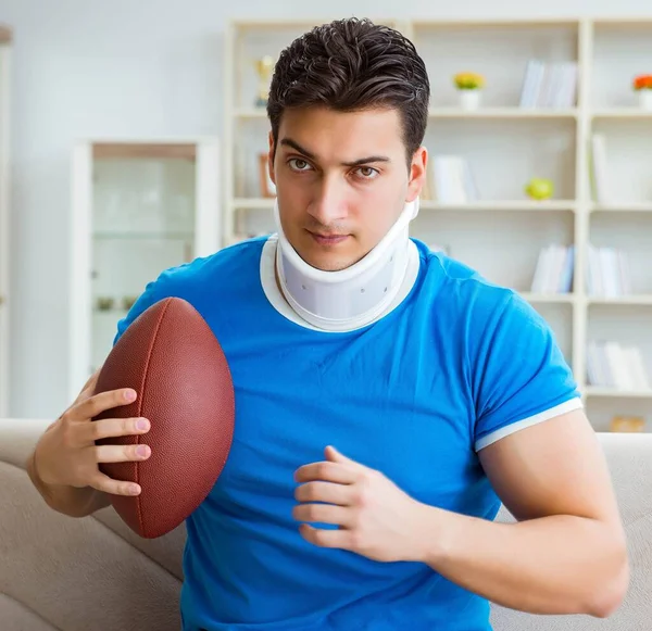 Homem com lesão no pescoço assistindo futebol americano em casa — Fotografia de Stock