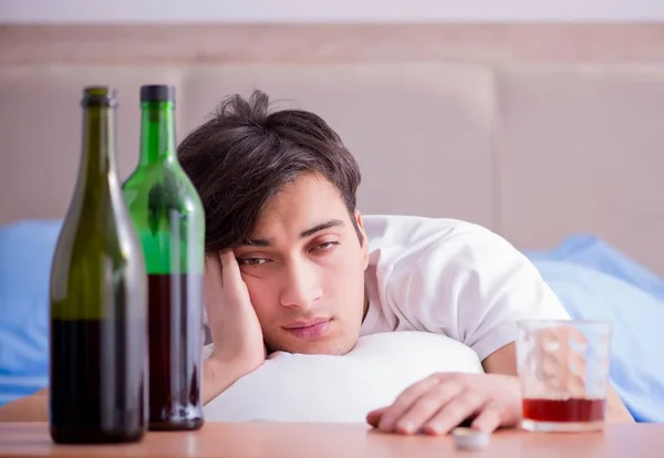 Man alkoholhaltiga drycker i sängen går igenom bryta upp depression — Stockfoto