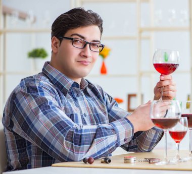 Profesyonel şarap garsonu kırmızı şarap tadıyor.