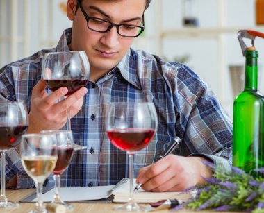 Profesyonel şarap garsonu kırmızı şarap tadıyor.