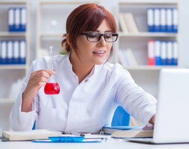 Bir laboratuarda deney yapan kadın bir bilim adamı.