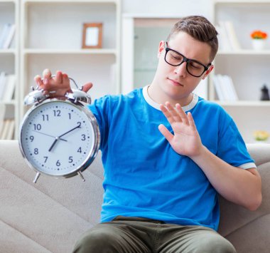 Sınavlara hazırlanan genç öğrenci kanepede ders çalışıyor.