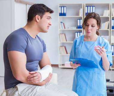 Hastanede yaralanma kontrolü sırasında doktor ve hasta.