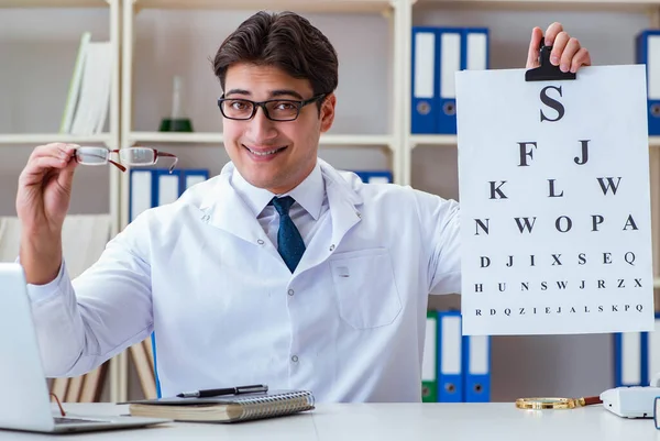 Médico óptico con carta gráfica llevando a cabo una comprobación de la prueba ocular —  Fotos de Stock