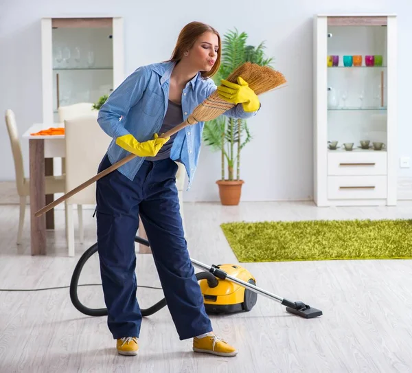 Junge Frau putzt Fußboden zu Hause und erledigt Hausarbeiten — Stockfoto