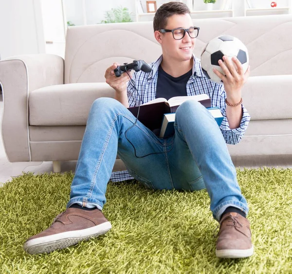 Jeune étudiant essayant d'équilibrer étudier et jouer à des jeux — Photo