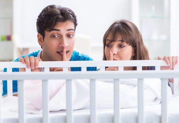 Happy young family at baby bed cot — Stock Photo, Image