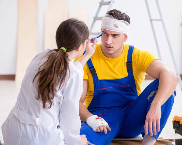 Worker with injured head and doctor