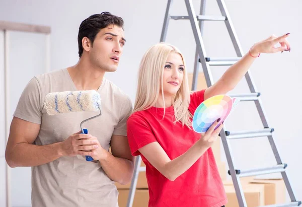 Молода сім'я займається живописом під час ремонту будинку — стокове фото
