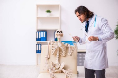 Deli doktor ölü hastayı muayene ediyor.