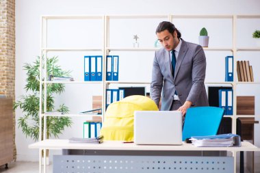 İş yerinde yeni doğan bebeğe bakan genç bir erkek işçi.