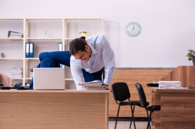 Genç erkek çalışan işyerinde fiziksel egzersiz yapıyor.