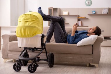 Evde bebekle ilgilenen genç bir müteahhit.