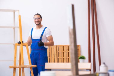 Genç erkek müteahhit atölyede çalışıyor.