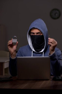 Erkek bilgisayar korsanı, güvenlik duvarını geç saatlerde hackliyor.