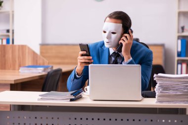 Ofiste maske takan genç bir erkek.