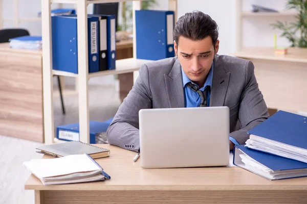 Young businessman employee unhappy with excessive work in the o — Stock Photo, Image