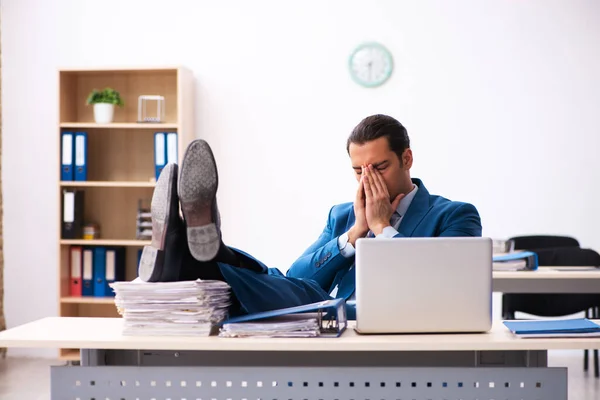 Jovem funcionário masculino infeliz com excesso de trabalho no escritório — Fotografia de Stock