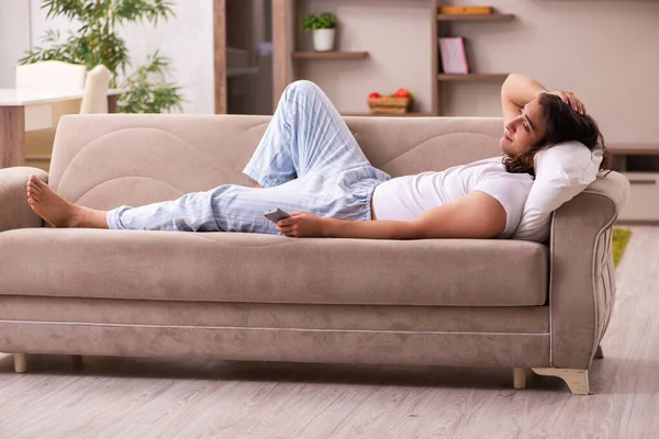 Young lazy man in oversleeping concept at home — Stock Photo, Image