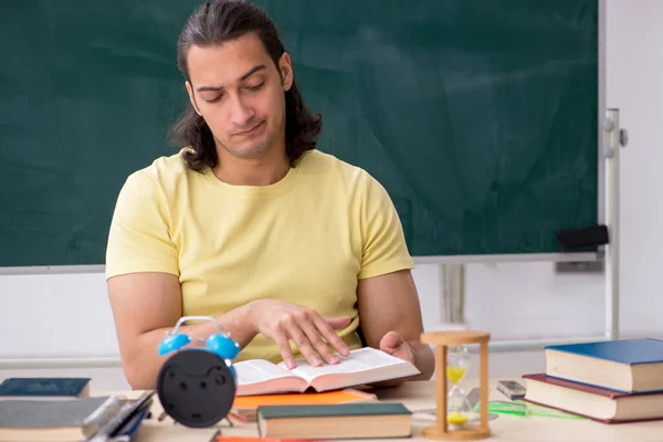 Ung manlig student förbereder sig för tentor i klassrummet — Stockfoto