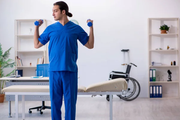 Молодий чоловік лікар фізіотерапевт робить спортивні вправи — стокове фото