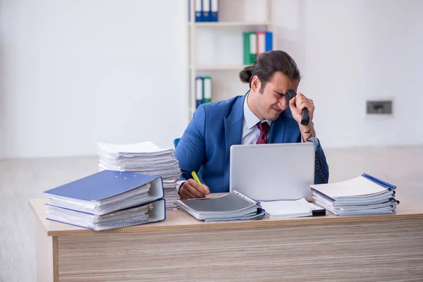 Jovem funcionário masculino infeliz com excesso de trabalho no escritório — Fotografia de Stock