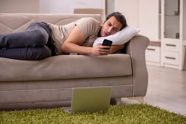 Молодой человек лежит дома на диване — стоковое фото