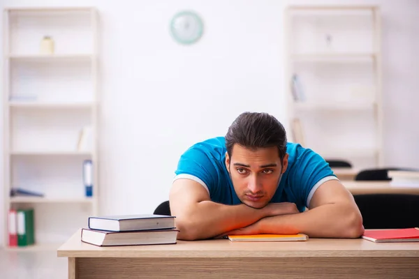 Estudiante agotado preparándose para los exámenes en el aula — Foto de Stock