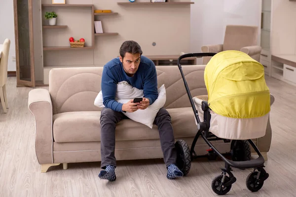 Jovem empreiteiro masculino cuidando do bebê em casa — Fotografia de Stock