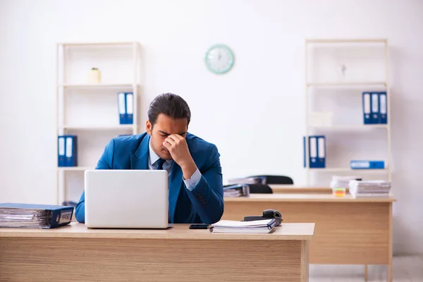 Young businessman employee unhappy with excessive work in the of — Stock Photo, Image