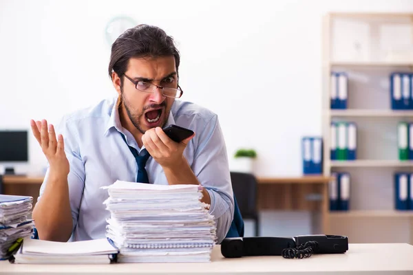 Молодий чоловік-працівник незадоволений надмірною роботою в офісі — стокове фото