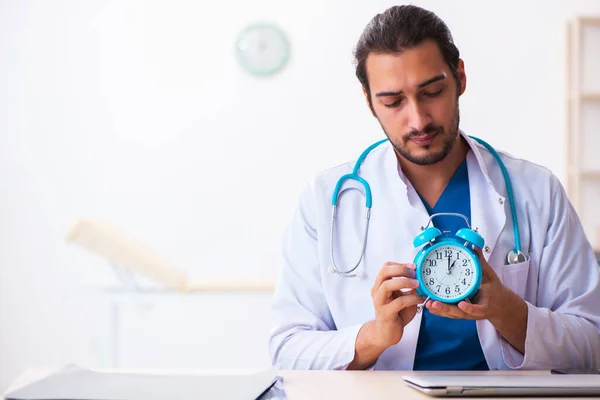 Joven médico masculino en concepto de gestión del tiempo — Foto de Stock