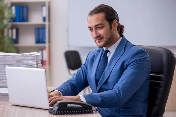 Jonge mannelijke werknemer en te veel werk op kantoor — Stockfoto