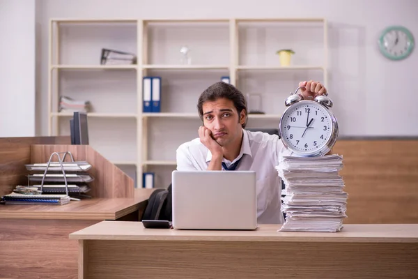 Jovem empregado do sexo masculino no conceito de gerenciamento de tempo no escritório — Fotografia de Stock