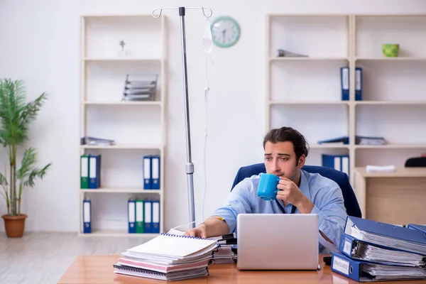 Giovane dipendente maschile che soffre sul posto di lavoro — Foto Stock