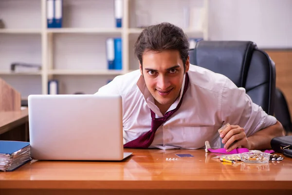 Молодий наркозалежний чоловік-працівник працює в офісі — стокове фото