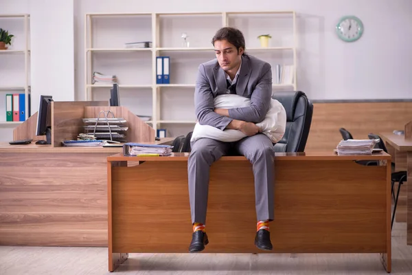 İş yerinde uyuyan genç bir erkek işçi.