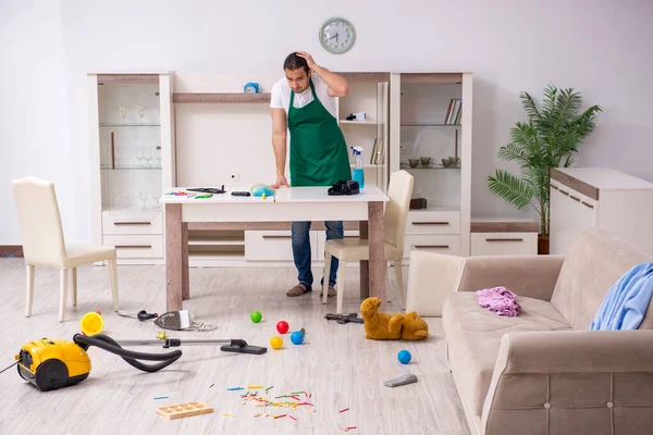 Young male contractor cleaning the flat after kids party — Stock Photo, Image